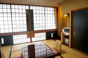 a living room with a large window and a chair at Bosenkan in Gero
