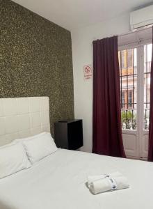 A bed or beds in a room at Apartamentos Day Madrid SANTO DOMINGO Centro Gran Via Sol Malasaña