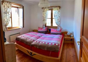 a bedroom with a large bed with pink pillows at LITTLE HIDEAWAY zillertal in Hart im Zillertal