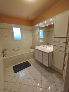 a bathroom with a tub and a sink and a mirror at parent aise in Azé