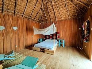 ein Schlafzimmer mit einem Bett in einem Zimmer mit Holzböden in der Unterkunft Bel Ami in Ouidah