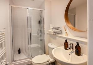 een badkamer met een douche, een toilet en een wastafel bij Rotheram (Suite) at Bicester Heritage in Bicester