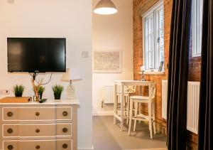 een woonkamer met een dressoir en een tv. bij Rotheram (Suite) at Bicester Heritage in Bicester