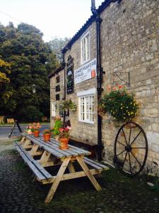 a wooden picnic table in front of a building at The Bull Inn West Tanfield in Ripon