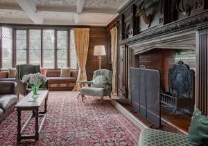 sala de estar con chimenea, sofá y sillas en Severn End - 15th Century Manor House!, en Hanley Castle