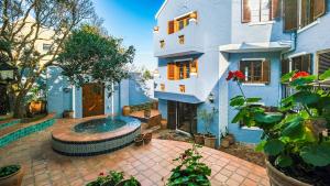 un edificio azul con una fuente frente a él en Milkwood Beach Villa, en Wilderness