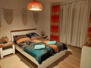 a bedroom with a bed and a chandelier at Apartament Muszelka 28 in Łeba