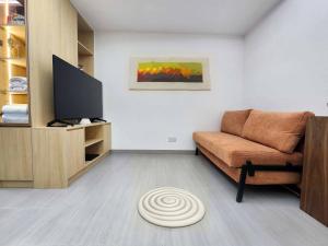 a living room with a couch and a flat screen tv at Pillows CoLiving in Hong Kong
