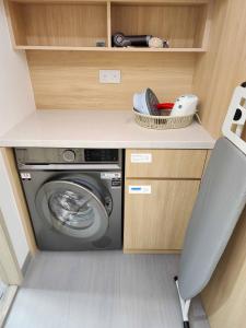 a laundry room with a washing machine and a chair at Pillows CoLiving in Hong Kong