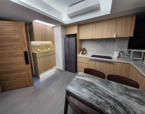a kitchen with wooden cabinets and a refrigerator at Pillows CoLiving in Hong Kong