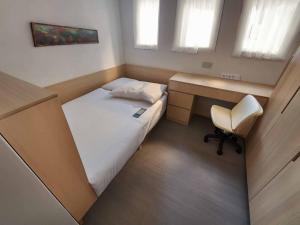 a small bedroom with a bed and a desk at Pillows CoLiving in Hong Kong