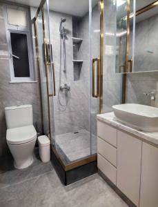 a bathroom with a shower and a toilet and a sink at Pillows CoLiving in Hong Kong