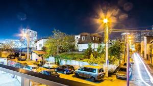 布加勒斯特Apartament rezidential Mihai Bravu cu internet de mare viteza si parcare gratuita的街上有汽车在晚上停在停车场