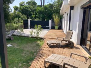 a wooden deck with two chairs and a table at villa bord de mer 400 M de la plage in Labenne