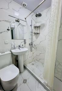 a white bathroom with a toilet and a sink at Hotel Soro in Samarkand +41 photos