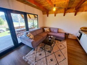 ein Wohnzimmer mit Sofa und Tisch in der Unterkunft Forest House Bukva in Ravne