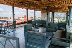 a deck with chairs and tables on a building at Les perles du bonheur Nyékonakpoé in Lomé