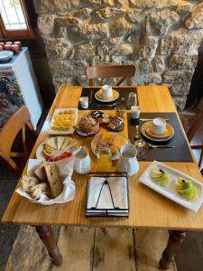 a wooden table with breakfast foods on it at Casa Rural Basiver - Habitación Pico San Carlos in Armaño +24 photos