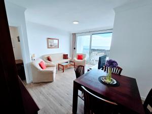 ein Wohnzimmer mit einem Tisch und ein Wohnzimmer mit Aussicht in der Unterkunft VV La Caracola "by henrypole home" in Breña Baja