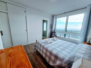 ein Schlafzimmer mit einem Bett und einem großen Fenster in der Unterkunft VV La Caracola "by henrypole home" in Breña Baja + 52 Fotos