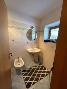 a bathroom with a sink and a mirror at Appartements Schatzer in Valdaora +16 photos
