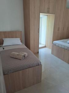 1 dormitorio con 2 camas y armarios de madera en Stara kamena kuca Lustica, en Luštica