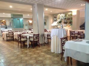 ein Esszimmer mit Tischen und Stühlen mit weißen Tischdecken in der Unterkunft Hotel Sacratif in Torrenueva