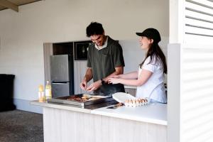 BolivarHighway 1 Holiday & Lifestyle Park的男人和女人在厨房里做饭