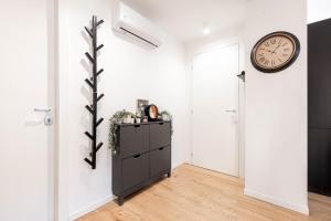 a room with a clock on the wall and a dresser at Ca' San Marco - Residenza di Lusso a Due Passi dalla Basilica in Vicenza