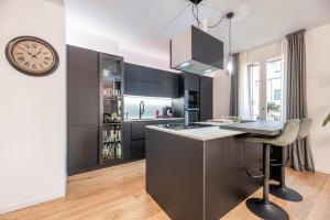 a kitchen with a counter and a clock on the wall at Ca' San Marco - Residenza di Lusso a Due Passi dalla Basilica in Vicenza