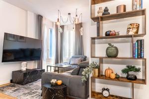 a living room with a couch and bookshelves at Ca' San Marco - Residenza di Lusso a Due Passi dalla Basilica in Vicenza