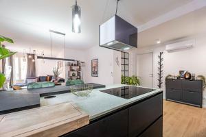 a kitchen with a black counter top and a living room at Ca' San Marco - Residenza di Lusso a Due Passi dalla Basilica in Vicenza