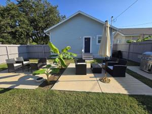 a yard with an umbrella and chairs and a fence at Luxury Designer Villa by the Beach Bright Beautiful Brand New in Galveston