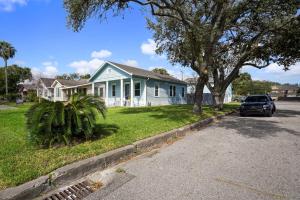a house with a car parked in front of it at Luxury Designer Villa by the Beach Bright Beautiful Brand New in Galveston