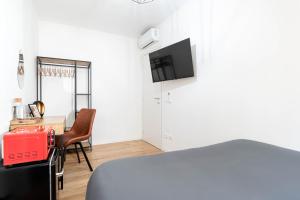 a room with a bed and a table with a television at Ca' San Marco - A Due Passi Dalla Basilica in Vicenza