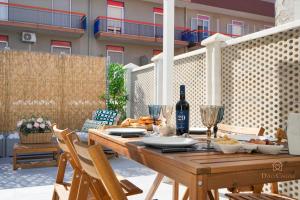 a wooden table with a bottle of wine on a patio at Downtown Apartments Dolci Coccole The Terrace in Bari