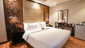 a bedroom with a large white bed and a desk at Boudl Al Majmaa in Al Majma'ah +25 photos