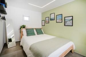 a bedroom with a white bed with pictures on the wall at Downtown Apartments Dolci Coccole The Terrace in Bari