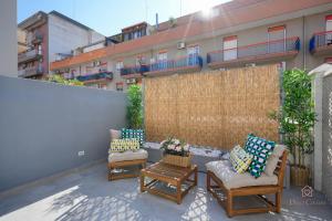 a patio with three chairs and a table and a fence at Downtown Apartments Dolci Coccole The Terrace in Bari