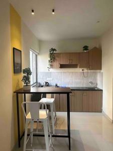 プネにあるSunflower Pvt Studio Room in Koregaon Park with AC WiFi Smart TVのキッチン(テーブル、白い椅子2脚付)