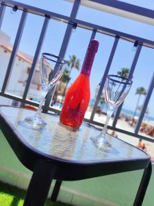a table with three wine glasses and a bottle on it at Los Deseos De Vera in La Cala de Mijas