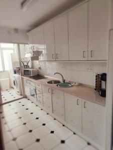 a kitchen with white cabinets and a sink at Los Deseos De Vera in La Cala de Mijas