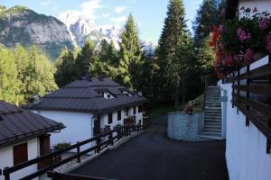 a road leading to a house with mountains in the background at Casa Lilly in Folgarida