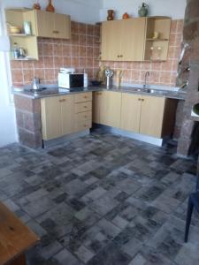 a kitchen with wooden cabinets and a tile floor at Casa lucas in Almáciga