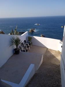 a patio with chairs and the ocean in the background at Casa lucas in Almáciga