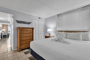 a bedroom with a large white bed and a dresser at Meridian Plaza 404 in Myrtle Beach