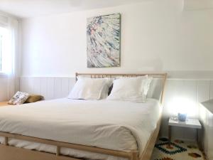 a bed with white sheets and pillows in a bedroom at L’appartement - Jardin Secret in Marseille +32 photos
