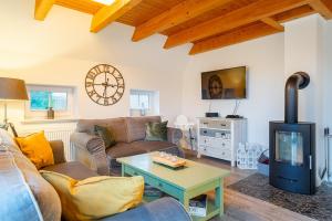 a living room with a couch and a tv at Ferienhaus NordseeStar in Neßmersiel