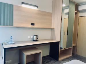 a room with a counter with a sink and a mirror at Hotel z Sanatorium Uzdrowiskowym Knieja Spa&Wellness in Supraśl