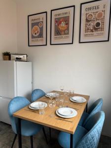 a wooden table with chairs and plates and wine glasses at Projektunterkunft Wörth nähe MIRO - Mercedes Benz - Dachser in Wörth am Rhein +9 photos